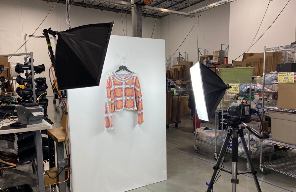 Sweater getting photographed in warehouse to be listed on e-commerce