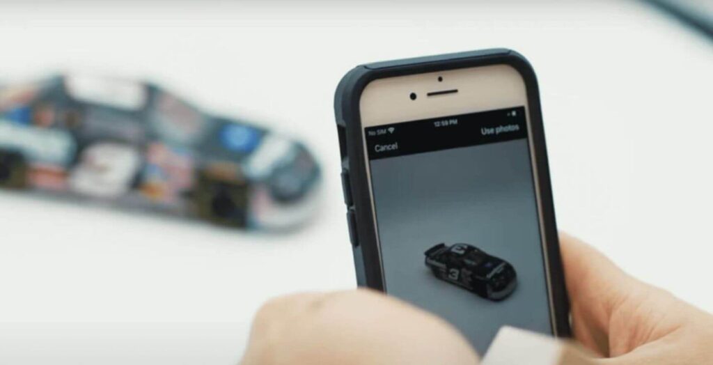 E-commerce software taking picture of toy race car to list on e-commerce