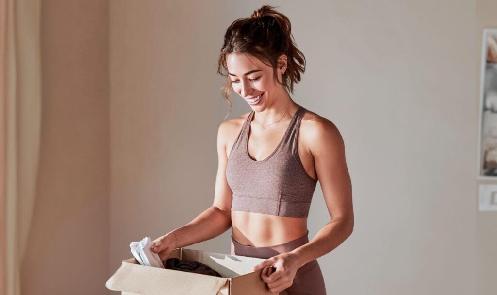Athletic woman opening up new package of workout leggings