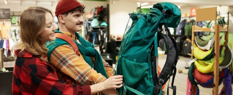 Happy loving couple choosing backpack for hiking and travel tour on weekend